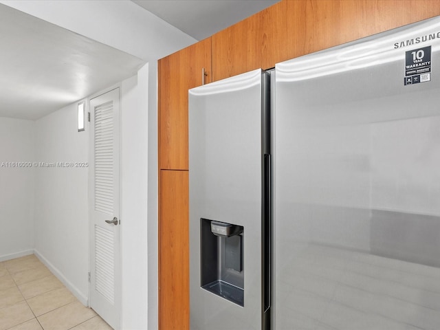 kitchen featuring stainless steel fridge and light tile patterned flooring