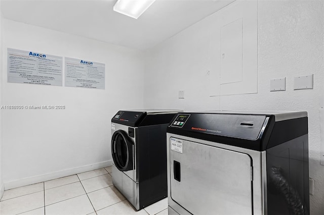 laundry area with separate washer and dryer and light tile patterned floors