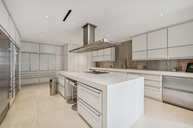 kitchen with island exhaust hood, black stovetop, white cabinetry, and a center island