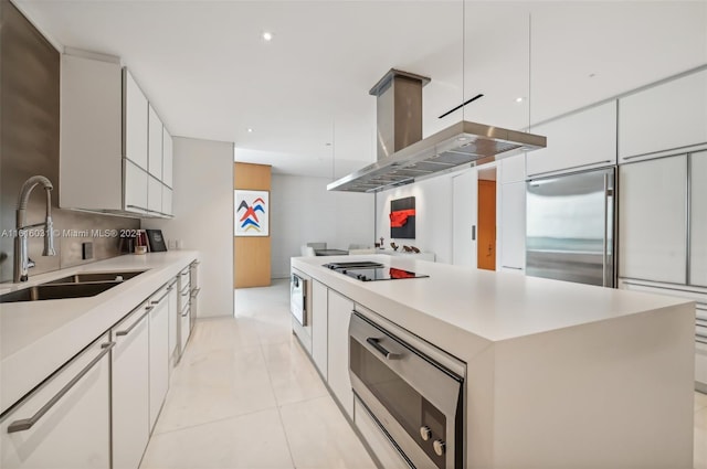 kitchen featuring a center island, white cabinets, built in appliances, sink, and ventilation hood