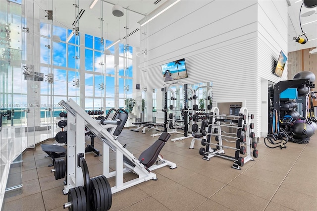 exercise room with a high ceiling and floor to ceiling windows