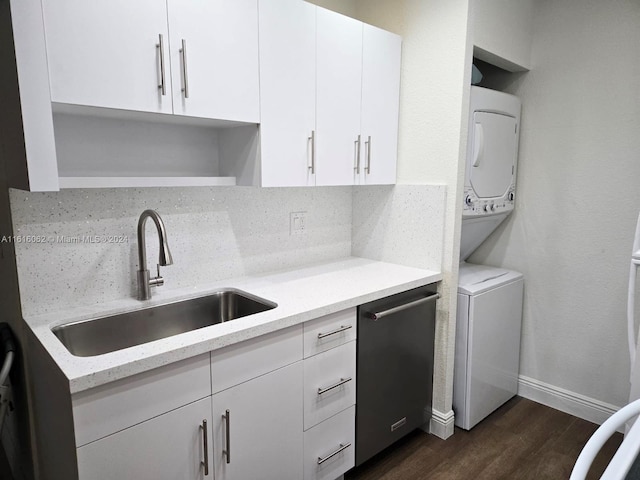 kitchen with light stone counters, sink, dark hardwood / wood-style floors, and stacked washer / drying machine