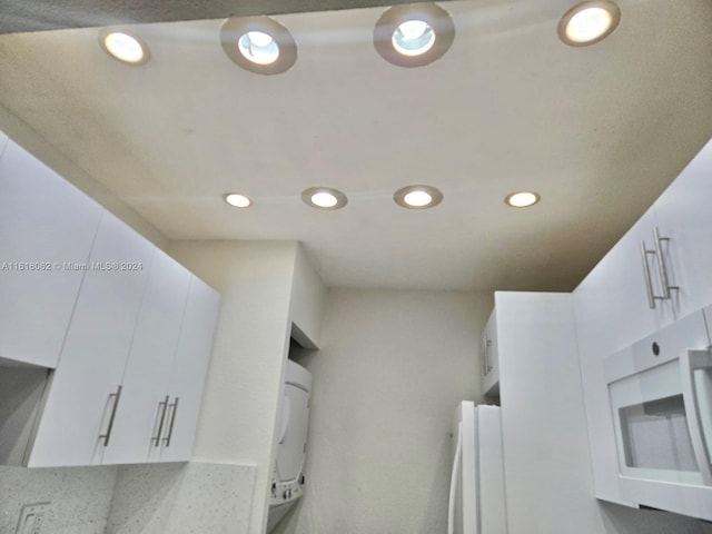 interior space featuring refrigerator and white cabinets