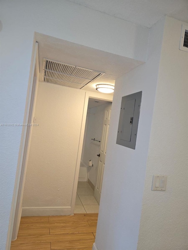 hallway with light wood-type flooring and electric panel