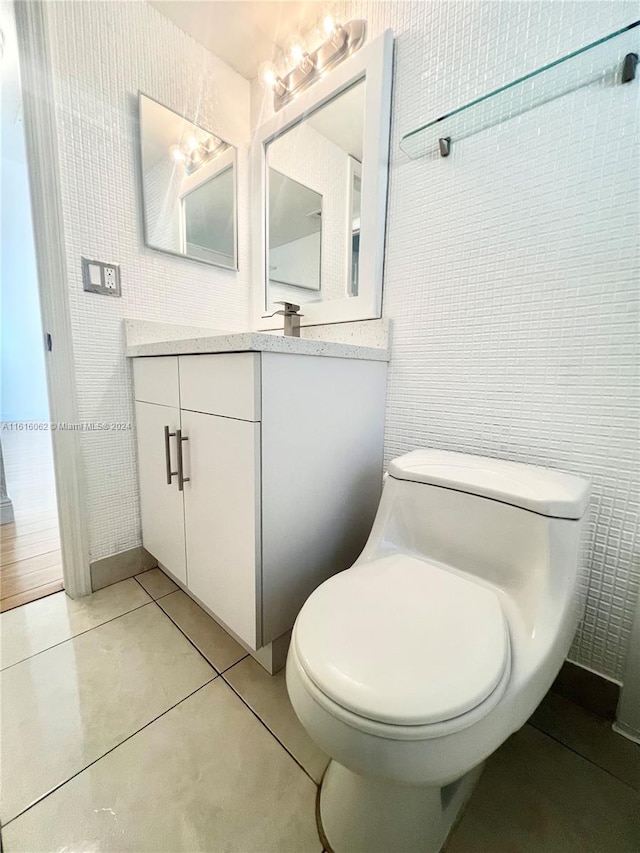 bathroom with tile patterned floors, vanity, toilet, and tile walls