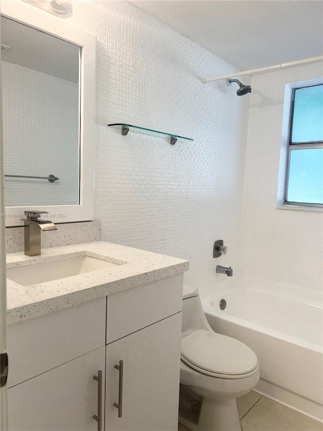 full bathroom featuring tile patterned flooring, vanity, tiled shower / bath combo, and toilet