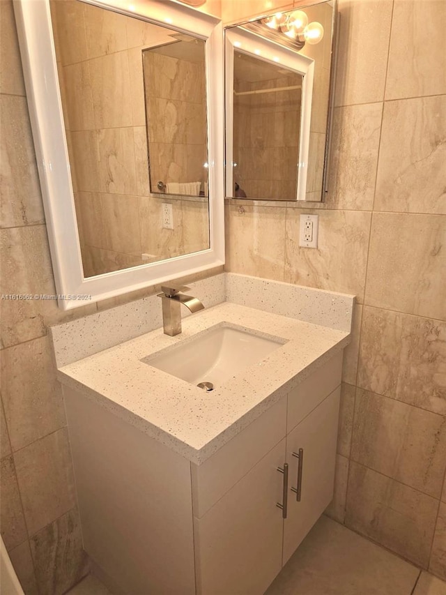 bathroom with vanity, tile walls, and backsplash