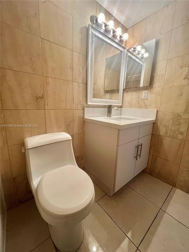 bathroom with tile patterned flooring, vanity, and tile walls