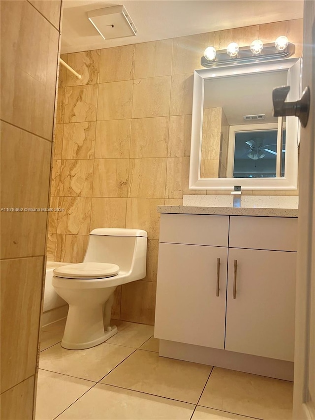 full bathroom with tile patterned flooring, vanity, and tile walls