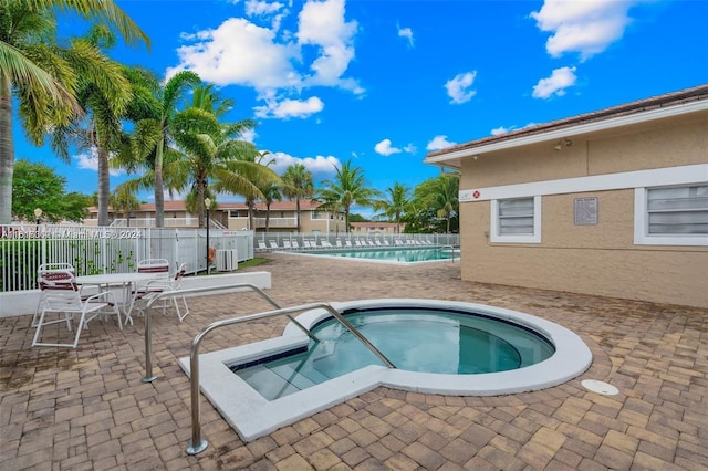 view of pool featuring a community hot tub and a patio area