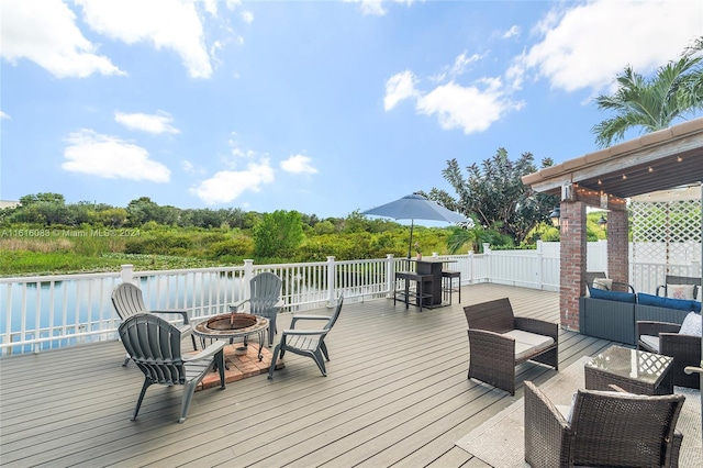 wooden deck featuring an outdoor living space with a fire pit