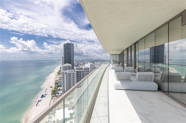 balcony with a water view and a view of the beach