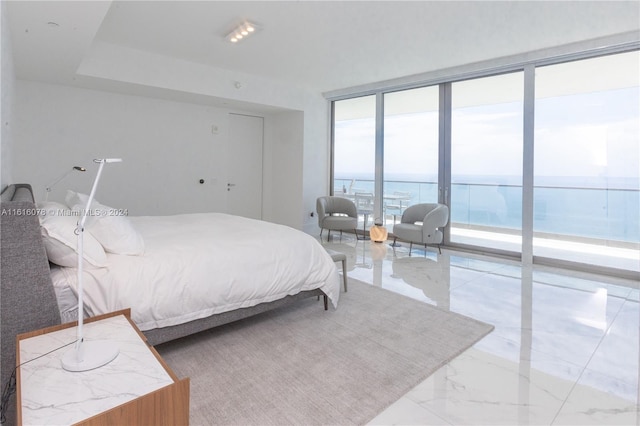 bedroom featuring light tile patterned flooring, a water view, access to exterior, and a wall of windows