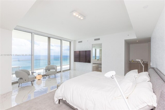 tiled bedroom with a water view, access to outside, and a wall of windows