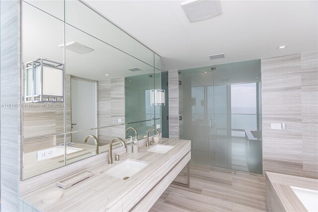 bathroom featuring tile walls, double sink vanity, tile patterned floors, and independent shower and bath