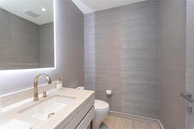 bathroom featuring tile walls, vanity, and toilet