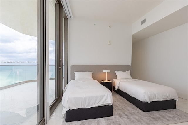 bedroom featuring a wall of windows, access to outside, and light tile patterned floors