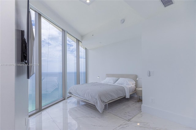 tiled bedroom featuring access to outside, a water view, and a wall of windows