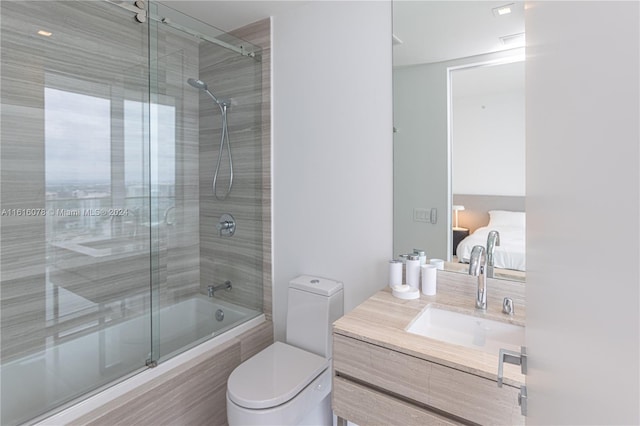 full bathroom featuring combined bath / shower with glass door, vanity, and toilet