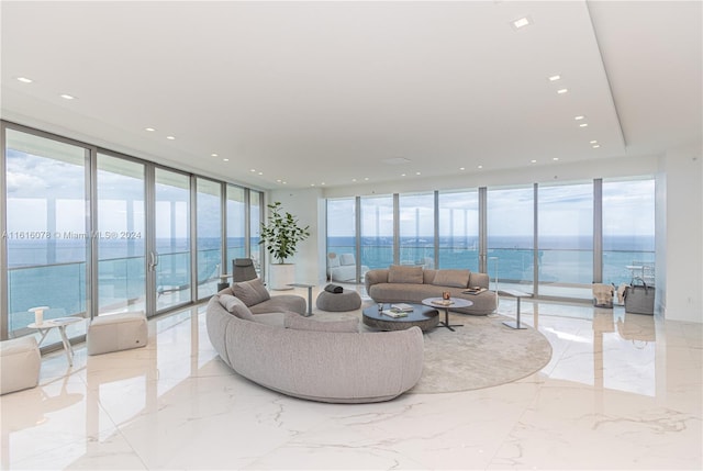 living room with floor to ceiling windows, a water view, and light tile patterned floors