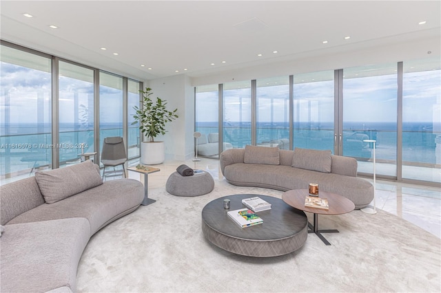 living room featuring floor to ceiling windows, a water view, and plenty of natural light