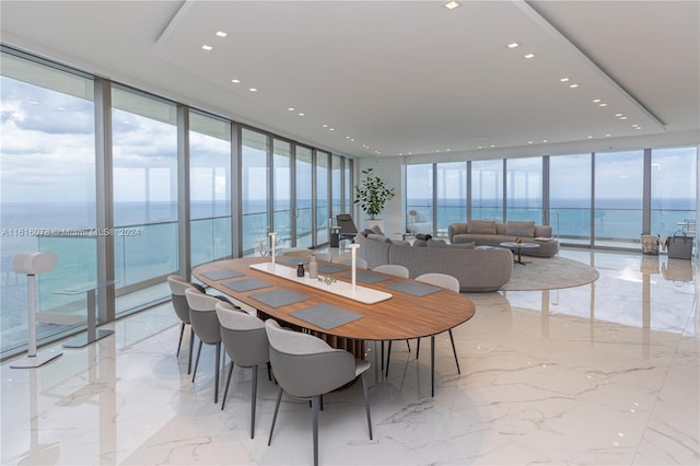 dining room with light tile patterned floors, expansive windows, and a water view