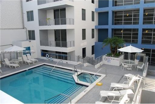 view of swimming pool featuring a community hot tub and a patio area