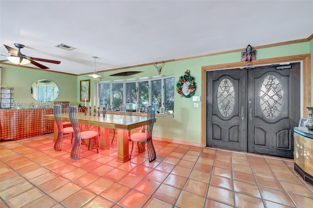 dining space with crown molding, tile patterned flooring, and ceiling fan