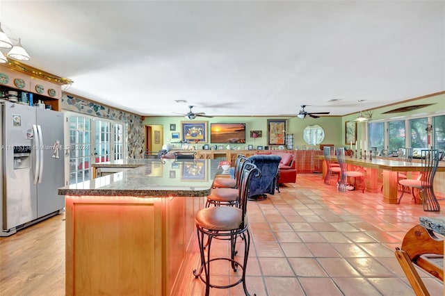 kitchen featuring ceiling fan, light tile patterned floors, and stainless steel fridge