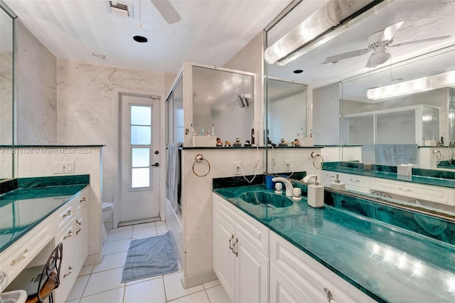 bathroom with toilet, vanity, tile patterned floors, and a shower with door