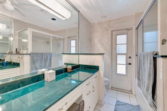 bathroom with vanity, walk in shower, toilet, and tile patterned floors