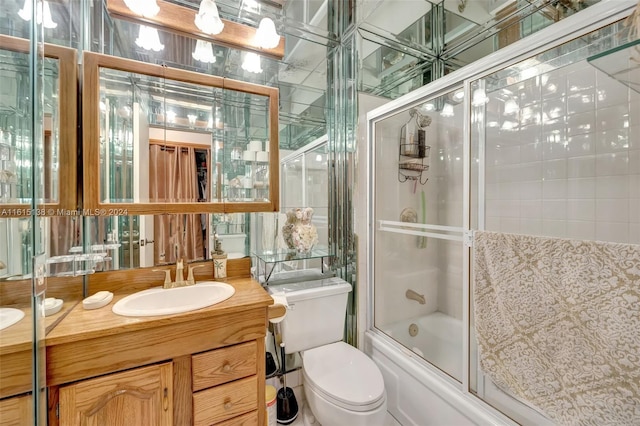 full bathroom with toilet, bath / shower combo with glass door, and vanity