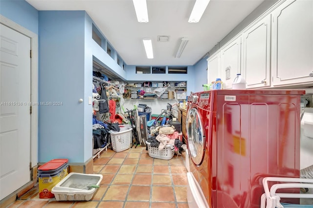 laundry room featuring washer and dryer, cabinets, and light tile patterned floors