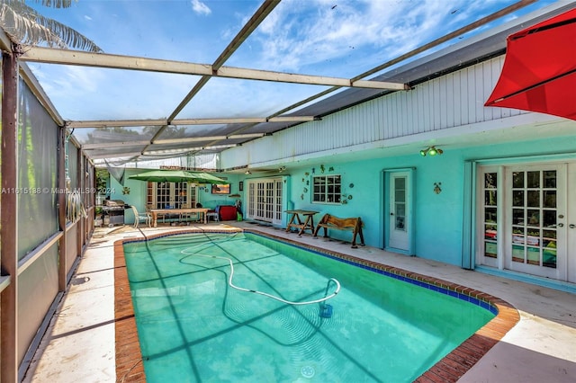 view of pool with french doors, a patio area, and a lanai