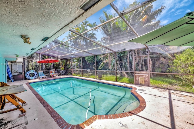 view of pool featuring a patio and glass enclosure