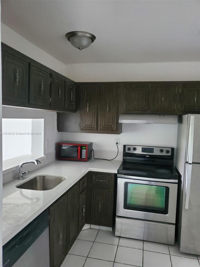 kitchen with light tile patterned floors, stainless steel appliances, and sink