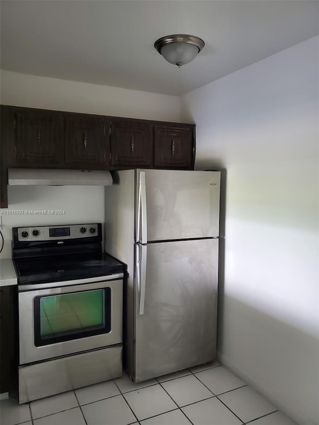 kitchen featuring appliances with stainless steel finishes, light tile patterned flooring, and dark brown cabinetry