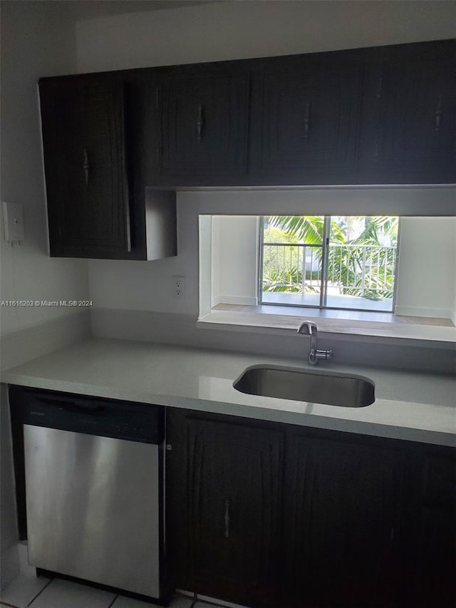 kitchen featuring light tile patterned flooring, stainless steel dishwasher, and sink