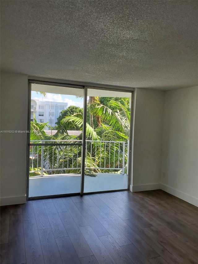 spare room featuring a textured ceiling and hardwood / wood-style floors