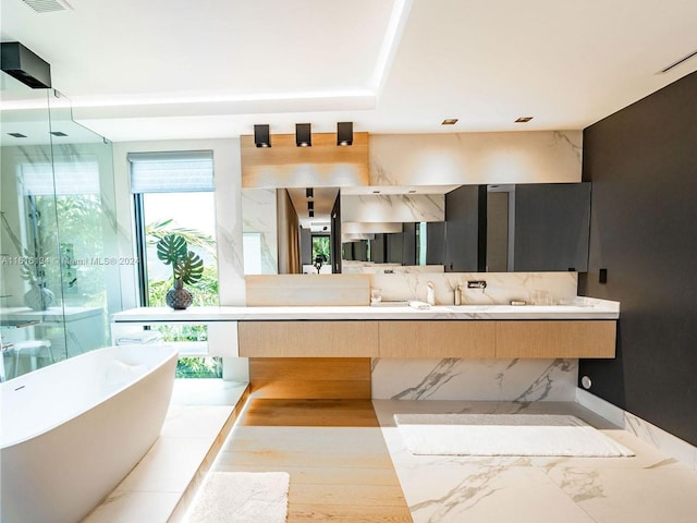 bathroom with hardwood / wood-style floors, vanity, and a bath