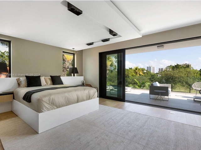 bedroom featuring access to exterior and light wood-type flooring