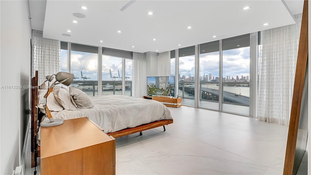 bedroom with multiple windows, access to outside, and a wall of windows