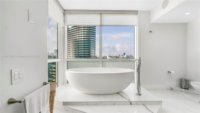 bathroom with a tub to relax in and toilet