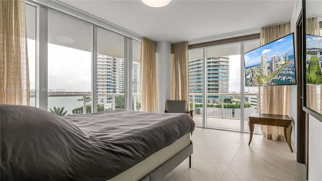 bedroom featuring access to exterior, light tile patterned flooring, expansive windows, and a water view