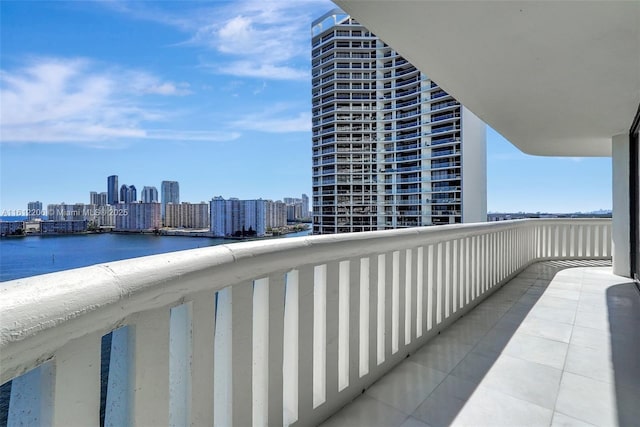 balcony featuring a water view and a city view