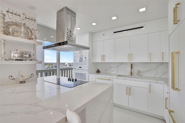 kitchen featuring light stone counters, island range hood, white appliances, white cabinets, and open shelves