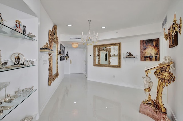 hallway featuring baseboards, marble finish floor, visible vents, and a notable chandelier