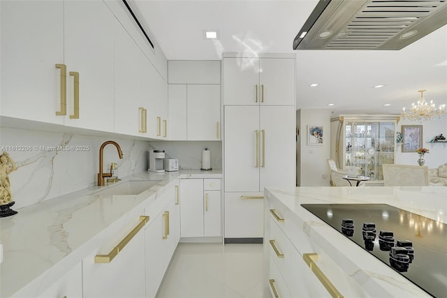 kitchen with white cabinetry, a sink, wall chimney exhaust hood, and black electric cooktop