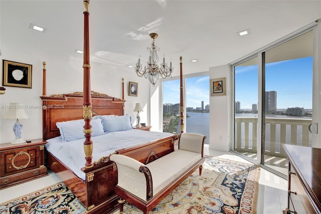 bedroom featuring a water view, access to exterior, a view of city, a wall of windows, and an inviting chandelier