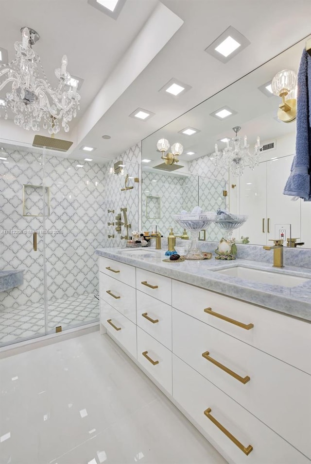 bathroom with double vanity, a shower stall, tile walls, and a sink